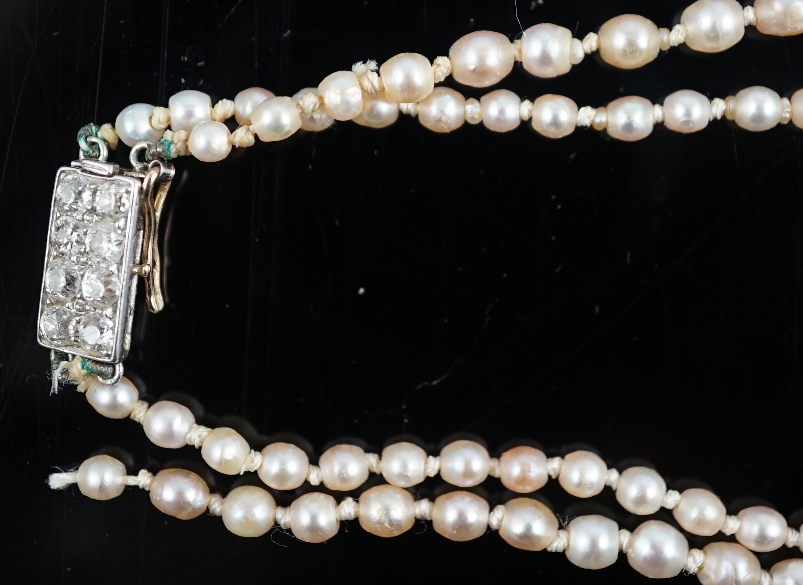 A twin strand graduated cultured pearl necklace, with gold and six stone diamond set rectangular clasp